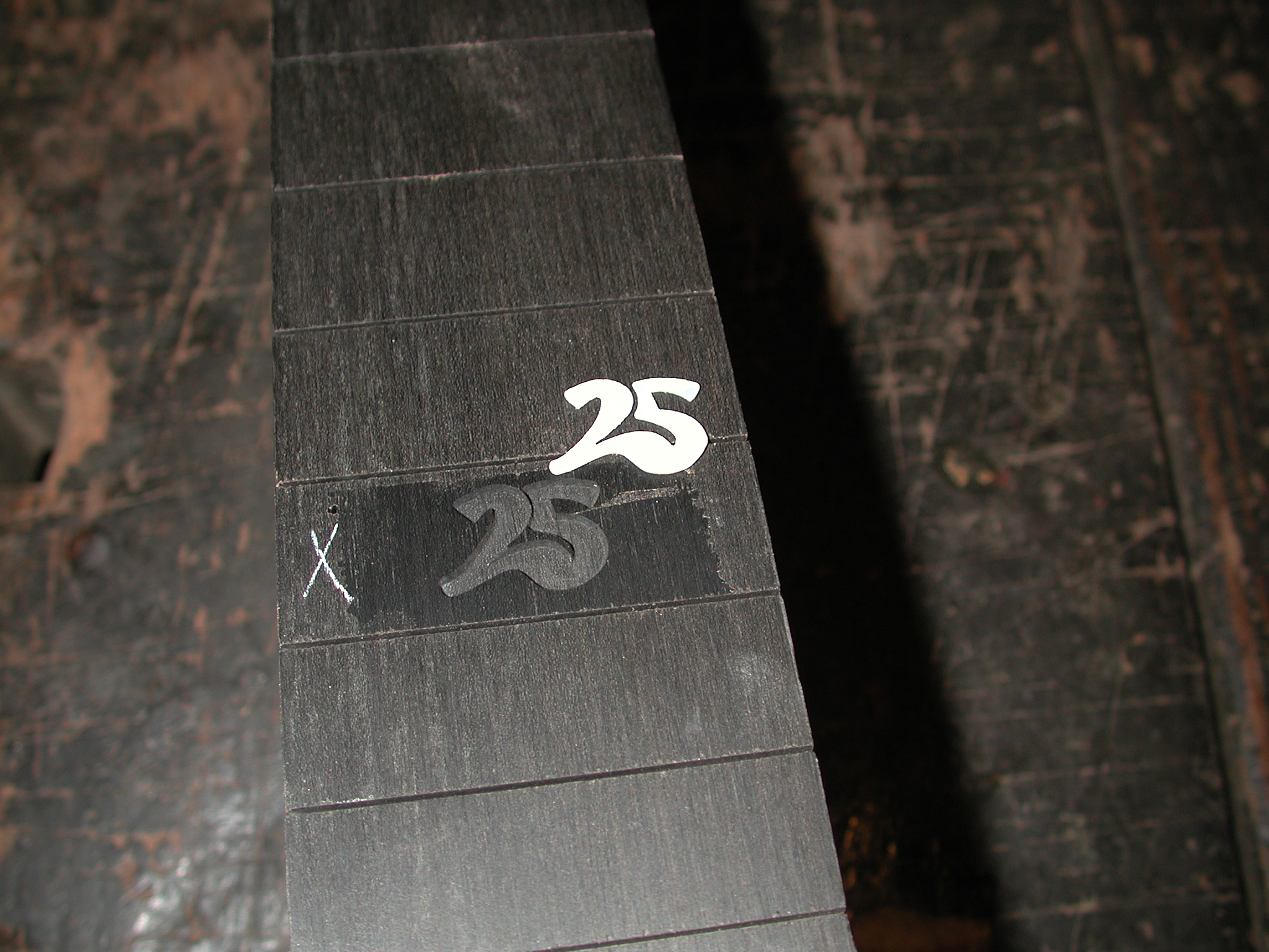 Fingerboard: The inlay "25" is fit into the cutout.