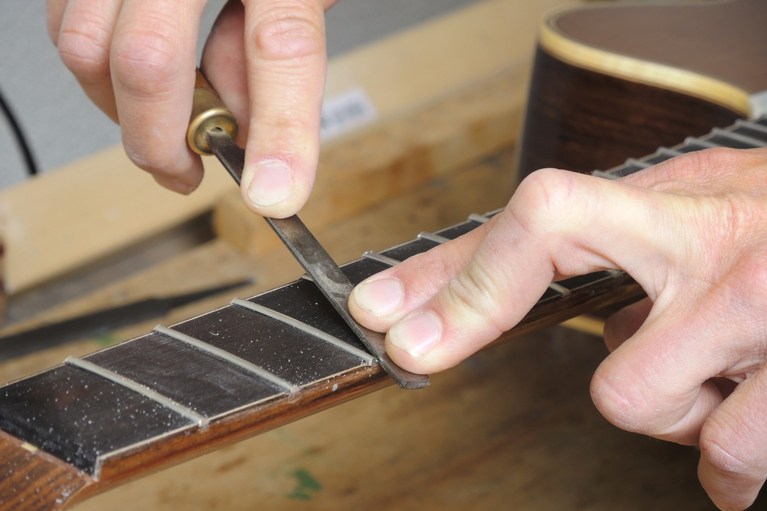 Re-fretting of an acoustic guitar - The lateral burr created by flush filing is removed